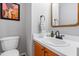 Cozy powder room featuring a sink with modern fixtures, wood cabinets and framed art at 202 Stonecreek Dr, Apex, NC 27539