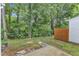 Backyard featuring a concrete patio, stone pavers, a partial fence, and lush greenery at 220 Misty Groves Cir, Morrisville, NC 27560