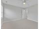 Spacious carpeted bedroom with a ceiling fan and a doorway leading to a bathroom at 220 Misty Groves Cir, Morrisville, NC 27560