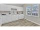 Bright kitchen features white cabinetry, quartz countertops, stainless steel faucet, and wood-look flooring at 220 Misty Groves Cir, Morrisville, NC 27560