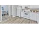Modern kitchen with white appliances, sleek countertops, and wood flooring seamlessly connecting to the dining area at 220 Misty Groves Cir, Morrisville, NC 27560