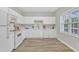 Well-lit kitchen featuring sleek white cabinets, modern appliances, and wood-look flooring, perfect for culinary adventures at 220 Misty Groves Cir, Morrisville, NC 27560