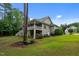 Expansive backyard featuring a two-story home with a covered deck, lush lawn, and mature trees at 2208 Wimberly Woods Dr, Sanford, NC 27330