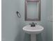 A pedestal sink with a framed mirror and a towel rack adorn the bathroom at 2208 Wimberly Woods Dr, Sanford, NC 27330