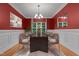 Elegant dining room with a modern table, chandelier, and bright red walls at 2208 Wimberly Woods Dr, Sanford, NC 27330