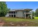 Rear exterior view of a two-story home with a covered deck and screened in porch surrounded by trees at 2208 Wimberly Woods Dr, Sanford, NC 27330