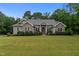 Charming home with stone accents, manicured landscaping, and a well-maintained lawn creates a welcoming curb appeal at 2208 Wimberly Woods Dr, Sanford, NC 27330