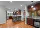 Gourmet kitchen featuring custom cabinets, hardwood floors, stainless steel appliances, and a stone breakfast bar at 2208 Wimberly Woods Dr, Sanford, NC 27330