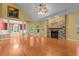 Spacious living room featuring a stone fireplace, hardwood floors, and an archway to the dining area, perfect for gatherings at 2208 Wimberly Woods Dr, Sanford, NC 27330