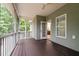View of a screened porch with wooden floors and access to the house's interior through a glass door at 2208 Wimberly Woods Dr, Sanford, NC 27330