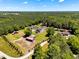 Expansive aerial view of several homes nestled amidst lush greenery and mature trees on a sprawling, picturesque landscape at 2258 Sanders Rd, Stem, NC 27581