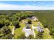 Aerial view of the property showcasing the home, outbuildings, and expansive tree coverage at 2258 Sanders Rd, Stem, NC 27581