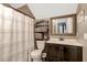 Cozy bathroom includes a shower with curtain, vanity with mirror, and a linen tower for storage at 2258 Sanders Rd, Stem, NC 27581