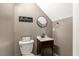 Chic half bathroom featuring modern fixtures, a round mirror, and compact design at 2258 Sanders Rd, Stem, NC 27581