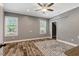 A spacious bedroom with hardwood floors, ceiling fan, and windows for abundant natural light at 2258 Sanders Rd, Stem, NC 27581