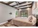 Comfortable bedroom featuring decorative ceiling beams and access to the backyard at 2258 Sanders Rd, Stem, NC 27581