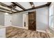 Stylish bedroom with wood beam ceiling, sliding barn door and hardwood floors at 2258 Sanders Rd, Stem, NC 27581