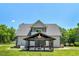 Back of house featuring a gray covered patio area, gray siding, and a grassy backyard at 2258 Sanders Rd, Stem, NC 27581