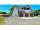Three-car garage with an upper balcony, ample parking space, and well-maintained landscaping at 2258 Sanders Rd, Stem, NC 27581