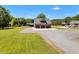 Spacious property featuring a three-car garage with an upper balcony, ample parking, and mature trees at 2258 Sanders Rd, Stem, NC 27581