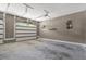 Spacious two car garage with a white garage door, open interior, and a wall-mounted shelf at 2258 Sanders Rd, Stem, NC 27581