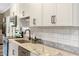Modern kitchen featuring granite countertops, stainless steel appliances, subway tile backsplash, and sleek cabinetry at 2258 Sanders Rd, Stem, NC 27581
