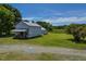 An aerial view shows a quaint, white, weathered barn set against a backdrop of verdant meadows and trees at 2371 Nc 210, Smithfield, NC 27577