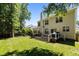 Expansive backyard featuring a lush lawn, a wooden deck, and mature trees provides a private oasis at 2412 Colony Woods Dr, Apex, NC 27523