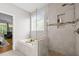 Bright bathroom featuring a soaking tub and glass shower, complemented by neutral tile and a serene atmosphere at 2412 Colony Woods Dr, Apex, NC 27523