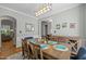 Formal dining room with hardwood floors, elegant table setting, and decorative lighting fixture at 2412 Colony Woods Dr, Apex, NC 27523