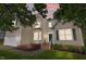 Two-story home featuring cream siding, a green front door, and attached garage at twilight at 2412 Colony Woods Dr, Apex, NC 27523