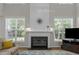 Close-up of the fireplace and entertainment center, flanked by large windows with a high ceiling at 2412 Colony Woods Dr, Apex, NC 27523