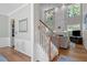 Inviting foyer with hardwood floors, staircase, and view into the living room with fireplace and large windows at 2412 Colony Woods Dr, Apex, NC 27523