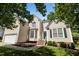 Charming two-story home with cream siding, manicured lawn, and inviting green front door at 2412 Colony Woods Dr, Apex, NC 27523