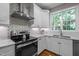 Kitchen featuring stainless steel range hood, modern appliances, and granite counters at 2412 Colony Woods Dr, Apex, NC 27523