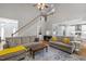 Open-concept living room leading into the kitchen, featuring a fireplace, high ceilings, and hardwood floors at 2412 Colony Woods Dr, Apex, NC 27523