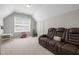 Spacious bonus room with comfortable seating, carpeted floors, and natural light, perfect for Gathering entertainment at 2412 Colony Woods Dr, Apex, NC 27523