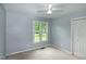 A bright bedroom with a ceiling fan, neutral carpet, and a window looking out to greenery at 2532 Rolling Meadows Dr, Raleigh, NC 27603