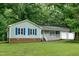 Charming home with a light-blue exterior, white porch, and lush green lawn at 2532 Rolling Meadows Dr, Raleigh, NC 27603