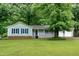 Charming single-story home with light green siding, blue shutters, and a well-manicured lawn at 2532 Rolling Meadows Dr, Raleigh, NC 27603