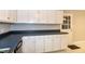 Kitchen with white cabinets, dark countertops, and an entry door nearby at 2532 Rolling Meadows Dr, Raleigh, NC 27603