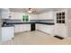 Bright kitchen with white cabinets, dark countertops, and checkered floors at 2532 Rolling Meadows Dr, Raleigh, NC 27603