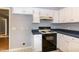Kitchen features white cabinets, black appliances, and dark blue countertops at 2532 Rolling Meadows Dr, Raleigh, NC 27603