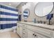 Bathroom with double vanity, granite counters, and blue striped shower curtain at 2538 Tuffeto, Apex, NC 27502