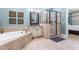 Bright bathroom with a soaking tub, glass shower, vanity, and tiled floors at 2538 Tuffeto, Apex, NC 27502
