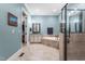 Luxurious bathroom featuring a soaking tub, glass shower, double vanity, and access to a walk-in closet at 2538 Tuffeto, Apex, NC 27502