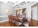 Dining room featuring coffered ceilings, stylish lighting, and seating for eight, creating a perfect ambiance at 2538 Tuffeto, Apex, NC 27502