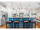 Eat-in kitchen featuring a blue island with barstool seating, stainless appliances, and hardwood flooring at 2538 Tuffeto, Apex, NC 27502