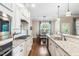 Well-appointed kitchen featuring white cabinets, granite counters, stainless steel appliances, and adjacent dining area at 2538 Tuffeto, Apex, NC 27502
