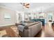 Bright living room with an oversized sectional couch, hardwood floors, and staircase in view at 2538 Tuffeto, Apex, NC 27502